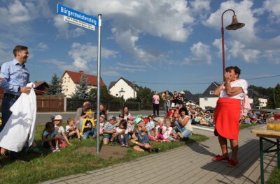 Ein eigener Gehweg für "Frau Bürgermeister" - In Hartmannsdorf gibt es seit Freitag einen "Bürgermeistersteig" zu Ehren von Bürgermeisterin Kerstin Nicolaus (CDU). Christfried Nicolaus, Anwärter für das Amt, enthüllte das Schild, das das Wirken seiner Mutter über drei Jahrzehnte für ihr Dorf würdigen soll. 
