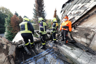 Ein Hilfseinsatz und neue Hoffnung - Feuerwehrleute im ausgebrannten Obergeschoss des Hauses in Rabenstein. Das Dach soll nun winterfest gemacht werden.