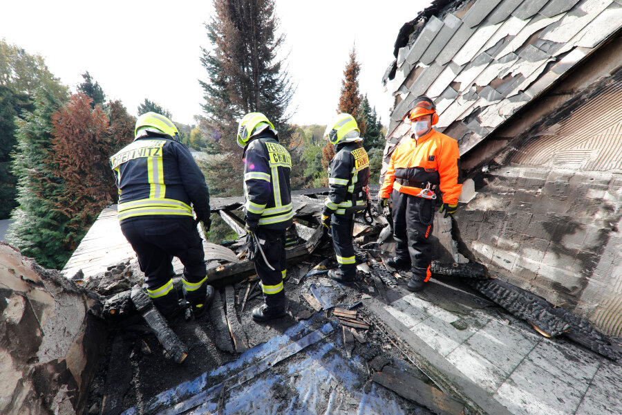Ein Hilfseinsatz und neue Hoffnung - Feuerwehrleute im ausgebrannten Obergeschoss des Hauses in Rabenstein. Das Dach soll nun winterfest gemacht werden.