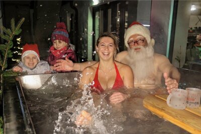 Ein Hohenstein-Ernstthaler lässt den Weihnachtsmann baden - Der Weihnachtsmann mit Franzi Weis (29) beim Anbaden im neuen Badezuber von Ron Richter am Donnerstagnachmittag. Dessen Töchter Ruby (7) und Penny (4) haben beim Zuschauen ihren Spaß.