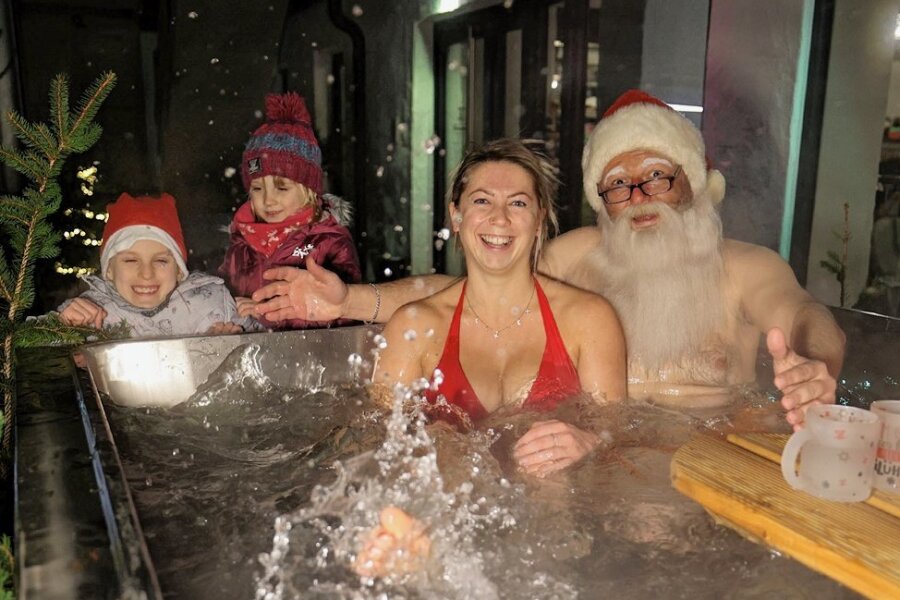 Ein Hohenstein-Ernstthaler lässt den Weihnachtsmann baden - Der Weihnachtsmann mit Franzi Weis (29) beim Anbaden im neuen Badezuber von Ron Richter am Donnerstagnachmittag. Dessen Töchter Ruby (7) und Penny (4) haben beim Zuschauen ihren Spaß.
