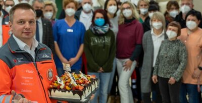 Ein Jahr Impfzentrum in Eich: Wie die Schwestern ihren Chef überrascht haben - Eine Torte und der Pokal für den Vogtländer des Jahres. Andy Feig wurde am Freitag von den Mitarbeitern des Impfzentrums gefeiert. 