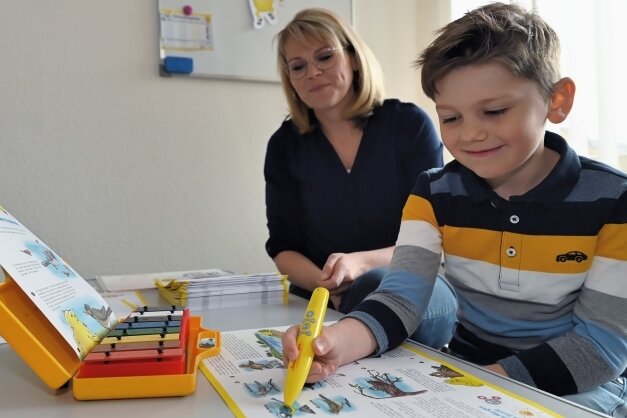 Ein kleiner gelber Stift unterstützt Musikschüler - Musiklehrerin Linda Knauf mit ihrem sechsjährigen Sohn Fabian, der Spaß hat beim Lernen mit dem Bookii-Trainingsstift.