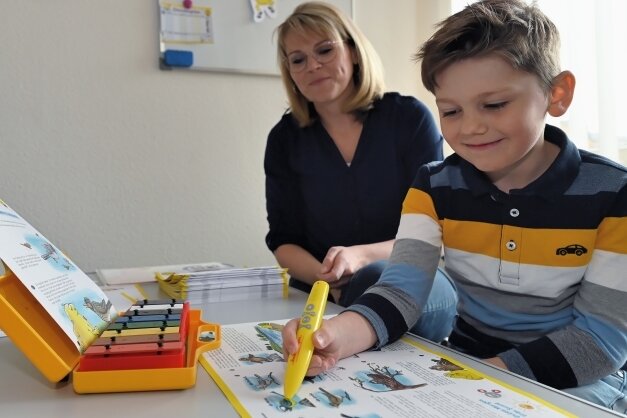 Ein kleiner gelber Stift unterstützt Musikschüler - Musiklehrerin Linda Knauf mit ihrem sechsjährigen Sohn Fabian, der Spaß hat beim Lernen mit dem Bookii-Trainingsstift.