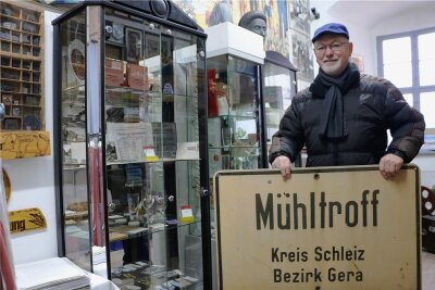 Ein Stück DDR-Museum findet im Schloss Mühltroff einen neuen Platz - Uwe Unger im neuen Ausstellungsraum im Schloss, der an die Mühltroffer Geschichte erinnert. Das Ortseingangsschild zeugt davon, dass die Stadt einst zum Kreis Schleiz und Bezirk Gera gehörte. 