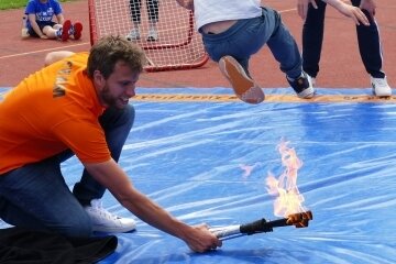 Durch den Sprung übers Feuer sollte der Mut der Kinder gestärkt werden. Weltmeister Dominik Klein (hinten) feuerte dabei an. 