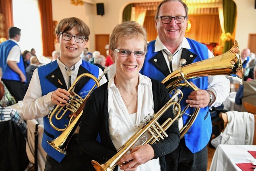Eine Geburtstagsfeier ohne Pauken, aber mit Trompeten in Großhartmannsdorf - Michael Timmel (rechts) ist  Vorstand des Blasorchesters. Auch seine Schwester Katrin Sallmann und ihr Sohn Noel (links) gehören dazu.