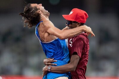 Eine Geschichte von Freundschaft, Fairness und Sportsgeist - Der goldene Moment. Gianmarco Tamberi (links) springt Mutaz Essa Barshim überglücklich in die Arme. 