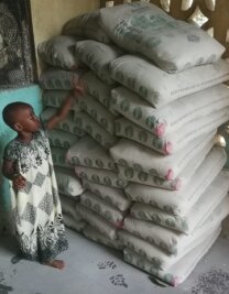 Einer Familie in Kenia zu Hütte verholfen - Die Tochter der Familie bestaunt die gelieferten Zementsäcke.