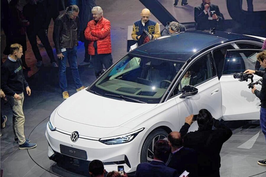 Elektro-Offensive: Volkswagen startet mit neuem ID.7 in die gehobene Mittelklasse - Gäste schauen sich bei der Weltpremiere des Modells in Berlin die neue Limousine VW ID.7 an. Das knapp fünf Meter lange Auto soll Reichweiten von voraussichtlich bis zu 700 Kilometern schaffen. 