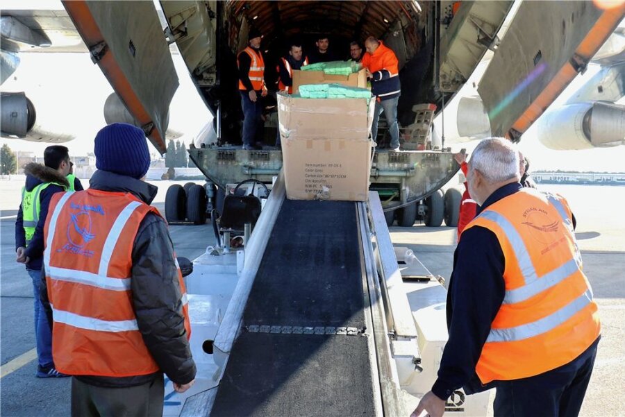 Elend und Machtspiele in Syrien - Auf diesem Foto der staatlichen syrischen Nachrichtenagentur SANA entladen Arbeiter am Flughafen in Aleppo, die humanitäre Hilfsgüter, die nach dem verheerenden Erdbeben nach Syrien geschickt wurden. 