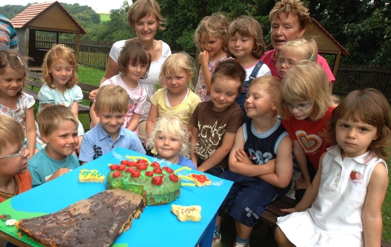 Kingergartenkinder mit Apfelbaumkuchen