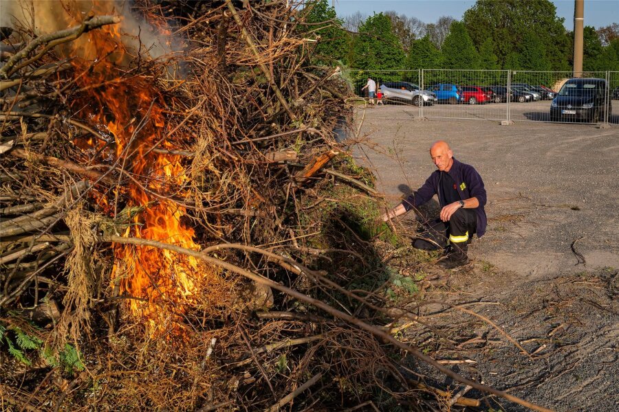 Endlich wieder Feuer auf dem Schützenplatz: So heiß startet Mittweida in den Mai - Lutz Schmidt fachte das Feuer auf dem Schützenplatz mit seinen Kameraden von der Freiwilligen Feuerwehr an.