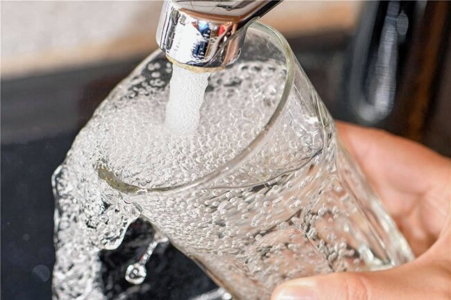 Energie- und Rohstoffkrise schlagen auf Wasserwerke Westerzgebirge durch: Zum 1. Juli steigen Gebühren für Trinkwasser und Abwasser - Im Verbandsgebiet der Wasserwerke Westerzgebirge steigen zum 1. Juli die Gebühren sowohl für Trink- als auch für Abwasser. Das Symbolbild zeigt, wie am Wasserhahn in einer Küche ein Trinkglas mit Leitungswasser gefüllt wird. 