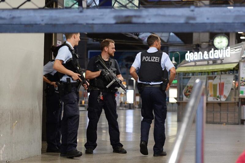 Ermittler: Münchner Amoklauf hat keinen Bezug zum IS - Polizisten mit Maschinenpistolen stehen in München am Hauptbahnhof und sichern das Gelände.
