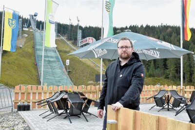 Erneuerter Biergarten in der Klingenthaler Vogtland-Arena: Endlich werden die Stühle umgeklappt - Arena-Mitarbeiter Christian Möckel freut sich über das neu gestaltete Ambiente. 