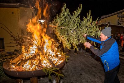 Erst geworfen, dann verbrannt: Niederlautersteiner wärmen sich am Christbaumfeuer - Mit einem kräftigen Stoß beförderte auch Thomas Macher seinen Weihnachtsbaum ins Feuer.