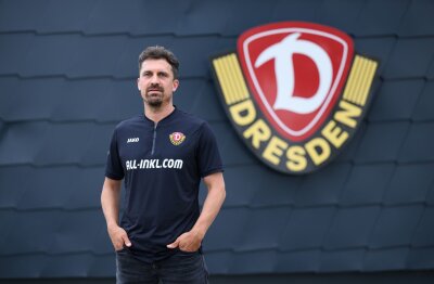 Erste Einheit von Trainer Stamm bei Dynamo Dresden - Thomas Stamm, neuer Trainer des Fußball-Drittligisten SG Dynamo Dresden, seht nach seiner Vorstellung in der Trainingsakademie vor dem Logo des Vereins.