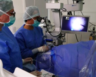 Erste Glaskörper-OP im Augenzentrum in Zschopau - Assistiert von Jasmin Schmidt, führt Prof. Dr. Kai Januschowski eine der ersten ambulanten Netzhautoperationen im Zschopauer Augenzentrum durch. Der Bildschirm zeigt den Eingriff vergrößert. 