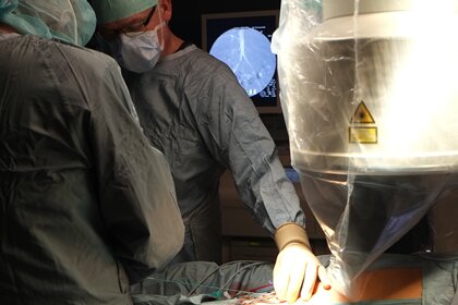 Erste Hybridoperation in Mittweida durchgeführt - Chefarzt Dr. Wurlitzer (li.) und Oberarzt Dr. Schnee (2.v.li.) während der Gefäßoperation. Rechts ist das Röntgengerät zu sehen, im Hintergrund sieht man auf dem Monitor das Röntgenbild der Gefäße.