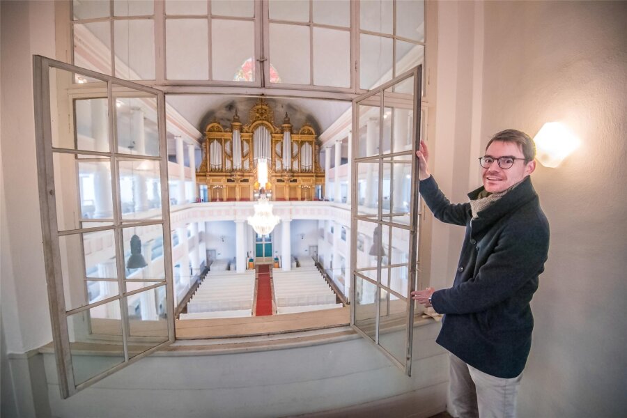 Erzgebirge: Lößnitzer Adventskalender ist so groß wie eine halbe Stadt - Das erste Adventstürchen in Lößnitz: Pfarrer Raphael Weiß am Engelsfenster in der St. Johanniskirche.