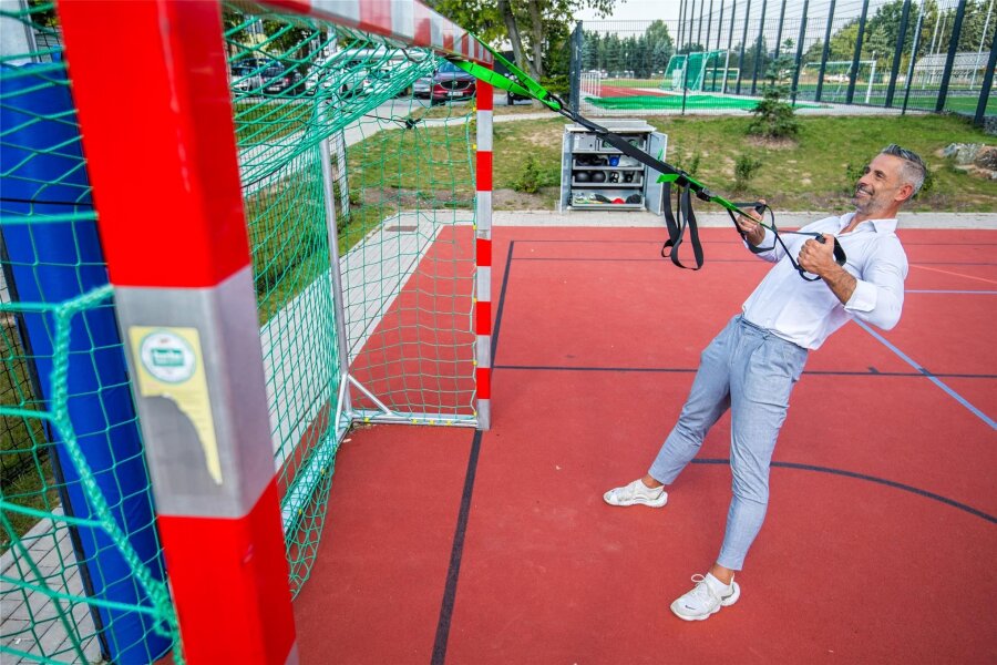 Erzgebirge macht sich fit: Hier lassen sich Sportgeräte per App ausleihen - Bürgermeister Albrecht Spindler probiert das Sportequipment aus der Sportbox am Schulcampus Leukersdorf aus.
