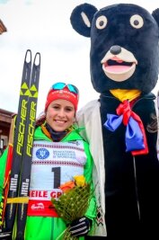 Erzgebirger stoßen zweimal auf Silber an - Silbermedaillengewinnerin Katharina Hennig und JWM-Maskottchen Braunbär Martin.