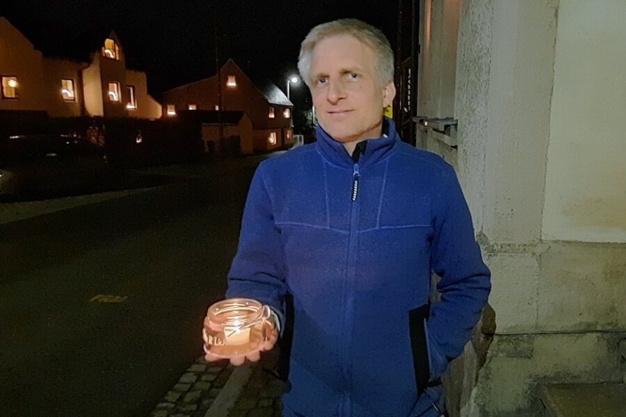 Lutz Uhlig stellt sich in Jahnsbach abends für zehn Minuten mit einer Kerze vor sein Wohnhaus. 