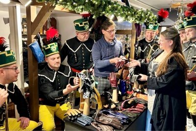 Erzgebirgischer Weihnachtsmarkt des Freistaats Sachsen in Brüssel endet mit neuem Besucherrekord - Die Mitglieder des Erzgebirgsensembles Aue am Stand von Handschuhmacher Nils Bergauer aus Schneeberg.