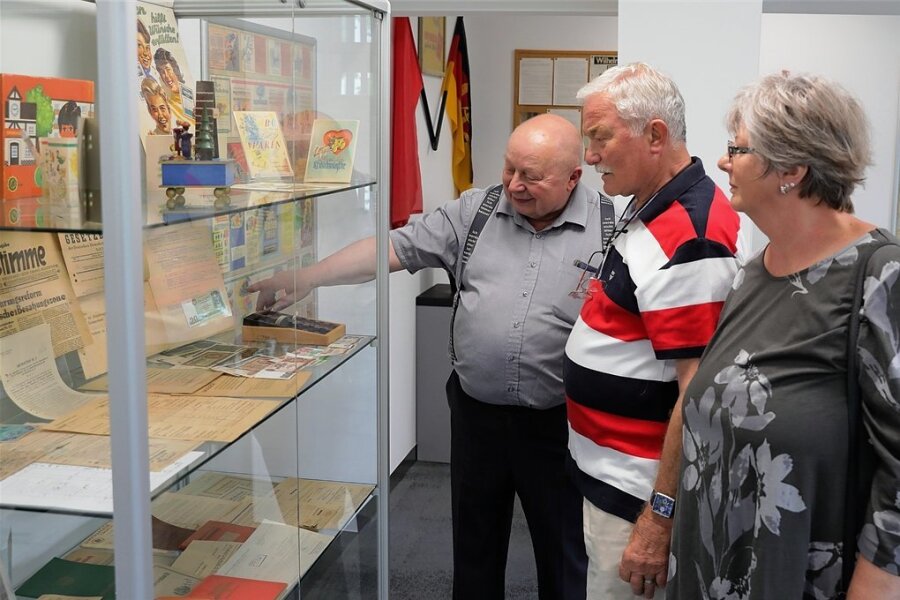 In der sparkassenhistorischen Ausstellung erzählt Horst Möckel (l.) Wolfgang und Birgit Weigel aus Bernsbach Anekdoten zum DDR-Geld. 
