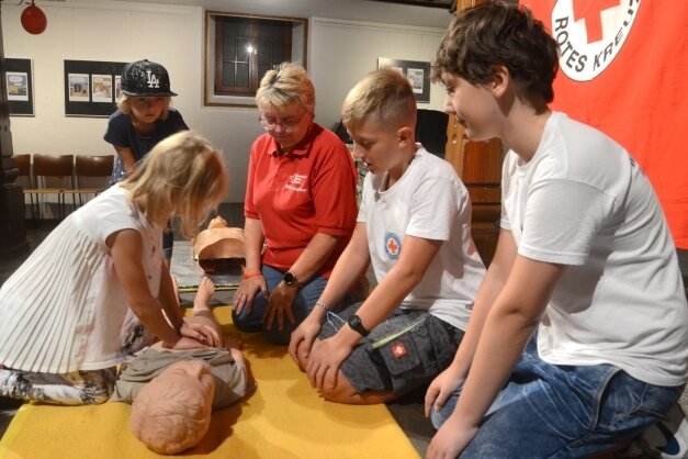 Paula übt unter Anleitung von Meike Junghänel sowie Justin und Henry von der Wasserwacht Rebesgrün eine Herzdruckmassage. 