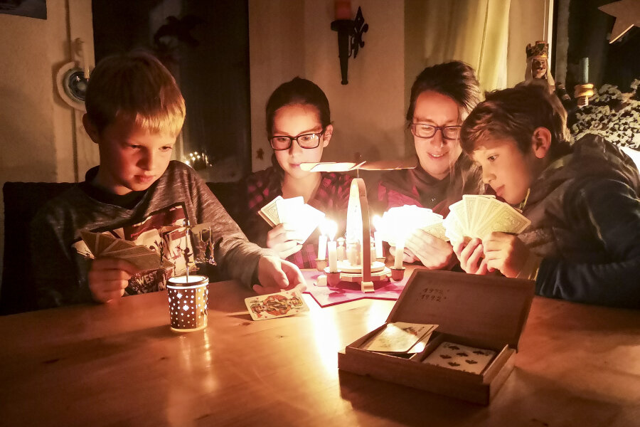 Etwa 4500 Haushalte im Erzgebirge am Donnerstag ohne Strom - Malte (11), Kira (14), Mutter Katja und Kalle (9) aus Geyer spielen zusammen Karten und machen das Beste aus dem Stromausfall.