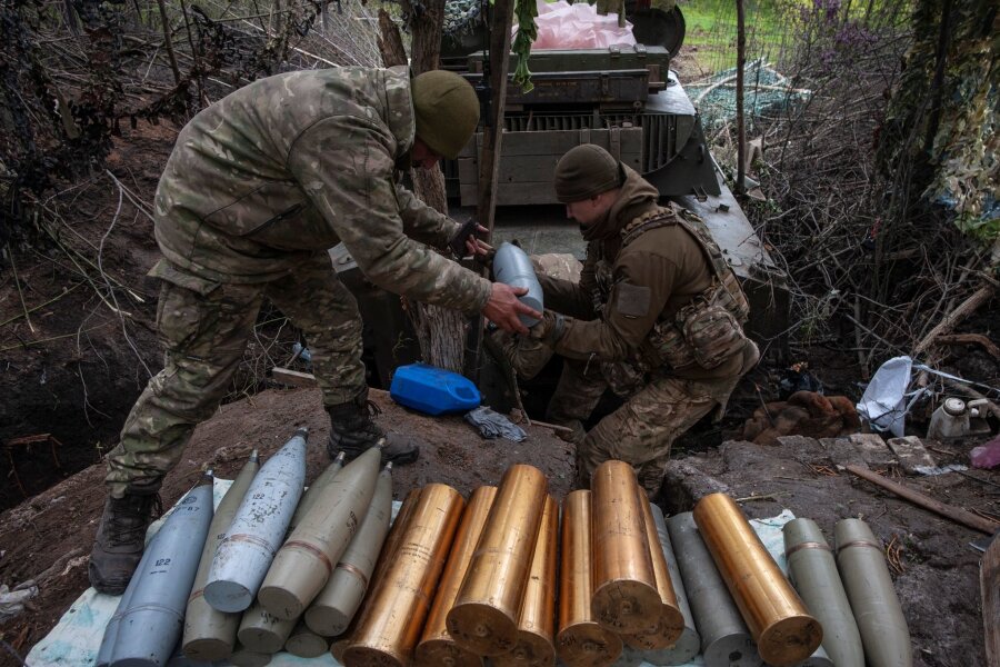 EU-Außenminister billigen Militärhilfen-Plan für Ukraine - Ukrainische Soldaten bereiten Haubitzengranaten vor.
