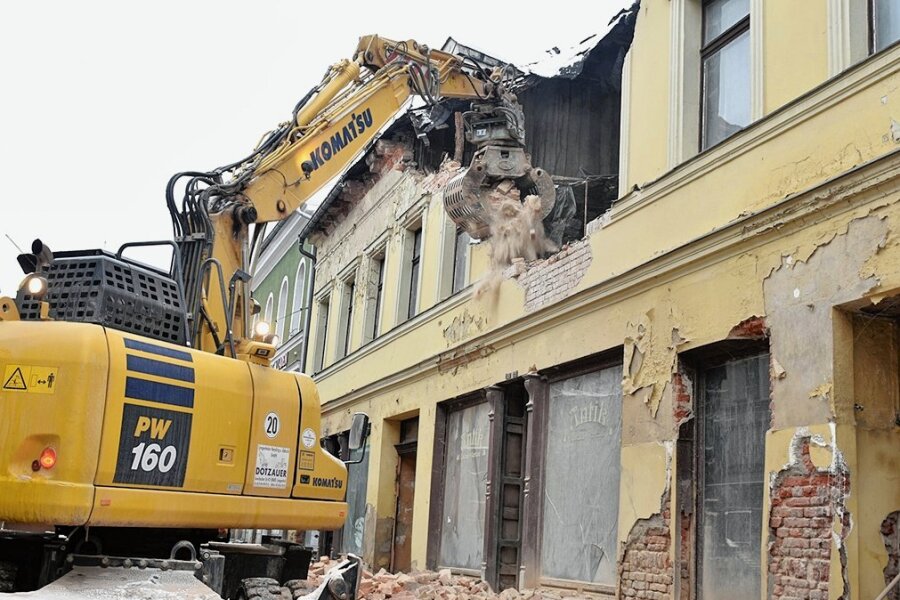 Ex-Eisdiele verschwindet: Händler in Markneukirchen kritisieren Vollsperrung in der Adventszeit - Der Bagger der Firma Lengenfelder Recycling und Abbruch frisst sich in die Fassade der ehemaligen Eisdiele in Markneukirchen. 