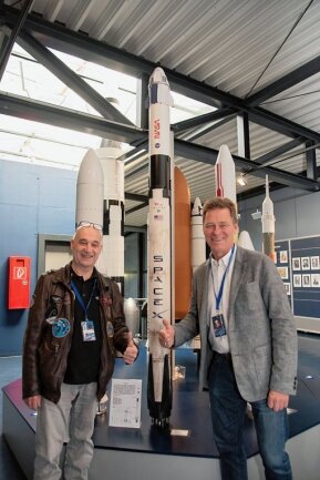 Ex-Mitarbeiter von Elon Musk bei Raumfahrttag in Morgenröthe-Rautenkranz - Raumfahrtingenieur Hans-Jörg Königsmann (rechts) und Volker Schmid vom Deutschen Zentrum für Luft- und Raumfahrt enthüllten am Samstag in der Ausstellung das Modell einer Falcon 9-Rakete.