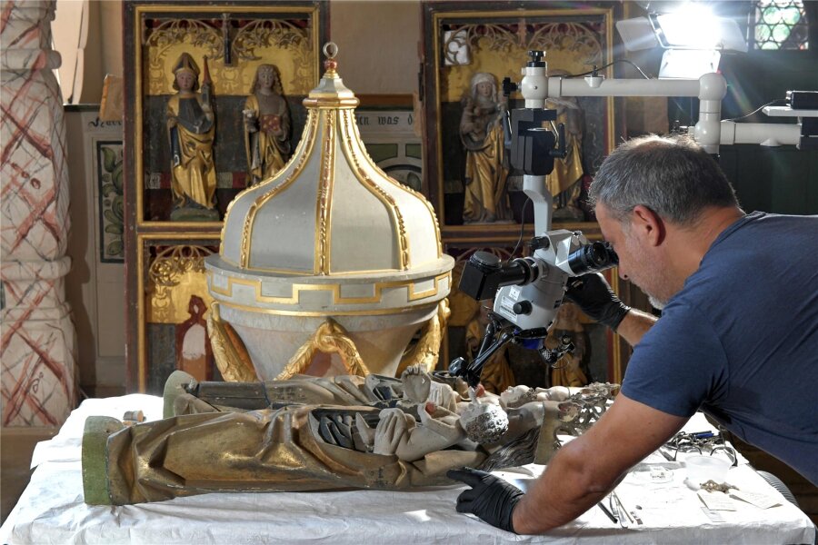 Experten geben Besuchern die Geheimnisse des Kirchenaltars in Burkersdorf preis - Restaurator Tino Simon schaut sich Details der Madonnen an, die den Altar in der Kirche zierten.