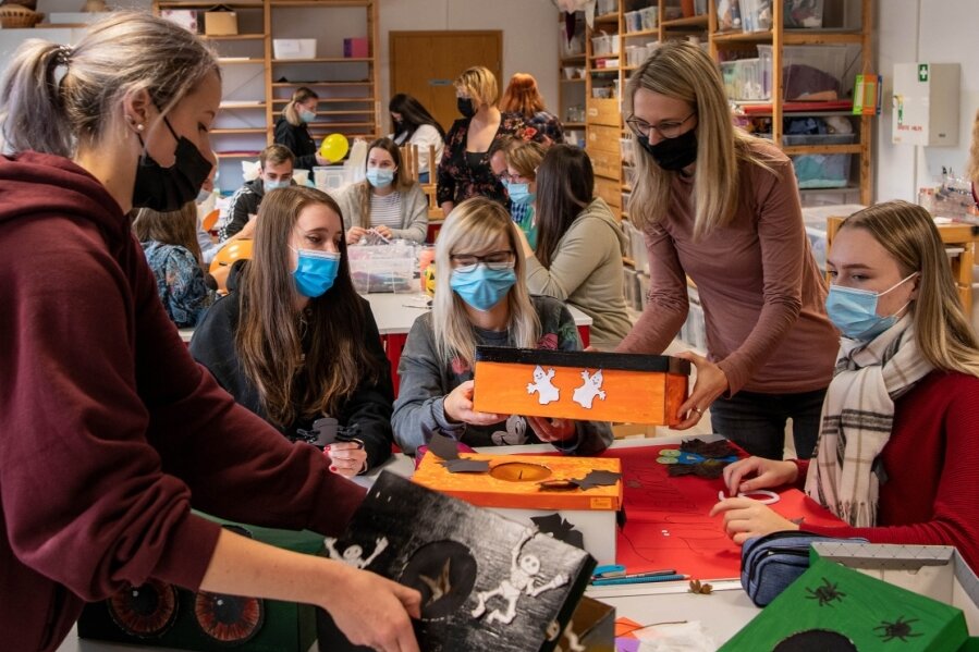 Schüler und Lehrkräfte arbeiten im Kreativraum der Euro-Akademie an Dekorationen und Spielen. 