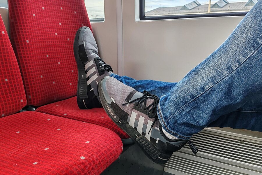 Fahrgast erhält "Reinigungsschein", weil er die Füße auf den Sitz legte - Gehört sich nicht: Die Schuhe auf dem gegenüberliegenden Sitz in der Zwickauer Straßenbahn. Wer dabei ertappt wird, muss für die Reinigung aufkommen.