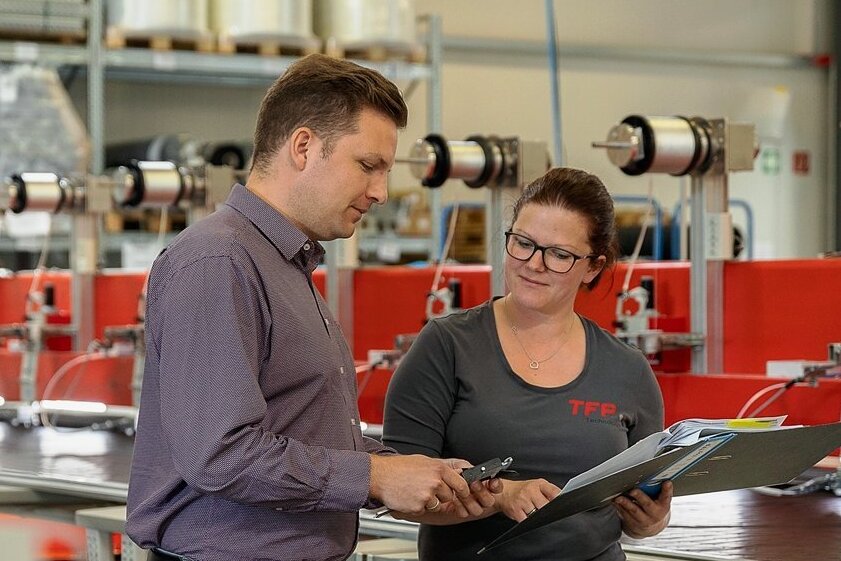 TFP-Betriebsleiter Steven Müller und Mandy Böhm, stellvertretende Produktionsleiterin, bei der Qualitätskontrolle an einer Elektroden-Stickmaschine. 