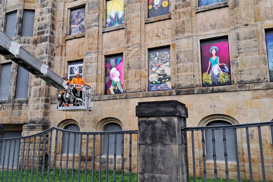 Falkensteiner Feuerwehr in Sachen „Kunst-Mission“ in luftiger Höhe unterwegs - Mitarbeiter von Bauhof und Feuerwehr montieren die Blumenkunst in den Fensternischen der Falgard-Fassade.