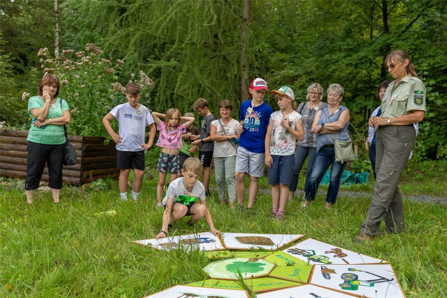 Familien befassen sich im Walderlebnisgarten Eich mit dem Thema Holz - Die Teilnehmer mit Ines Bimberg vom Forstbezirk Plauen (rechts).