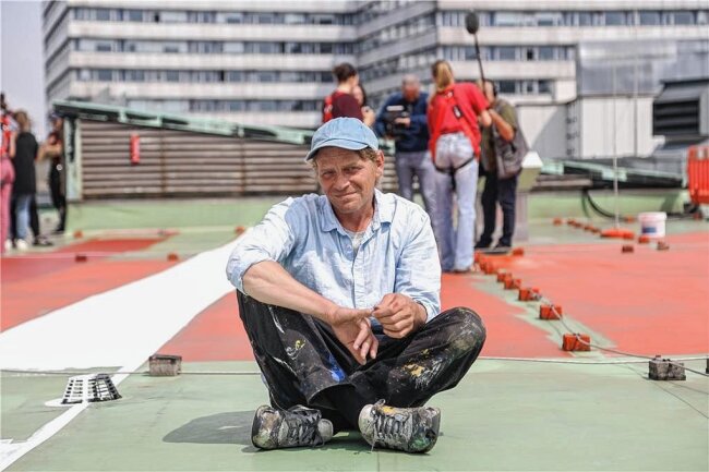 Farbe aufs Dach: Wie die Chemnitzer Stadthalle zum Kunstwerk wird - Der belgische Künstler Larsen Bervoets tourt durch Europa, um Dachflächen zu bemalen. 