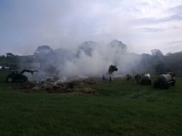 Feldscheune in Flammen - Um die Glutnester in den Heuballen zu löschen, breiteten Bagger die Reste der Ballen großflächig aus.