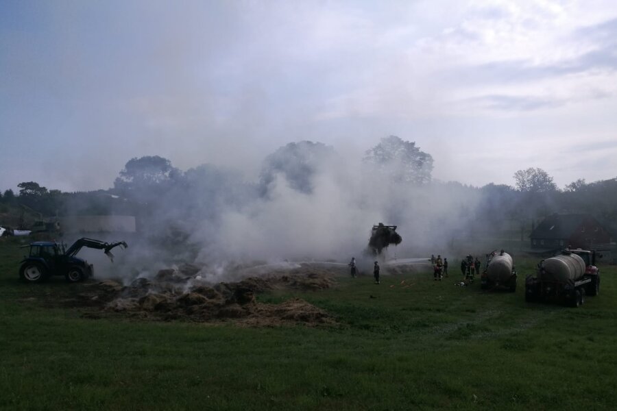 Feldscheune in Flammen - Um die Glutnester in den Heuballen zu löschen, breiteten Bagger die Reste der Ballen großflächig aus.