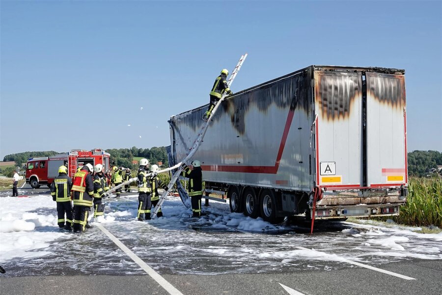 Feuer auf Bundesstraße: Plötzlich steht der Lkw-Auflieger in Flammen - Feuerwehrleute löschen am Freitag den in Brand geratenen Auflieger.
