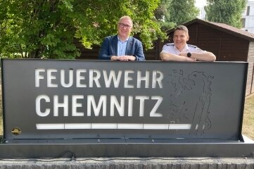Feuerwache erhält neues Signet - Der Amtsleiter der Feuerwehr, René Kraus (r.), und der Betriebsleiter von ITC Heckert, Bernd Stumm, am Signet vor dem Haupteingang der Feuerwache 1. 