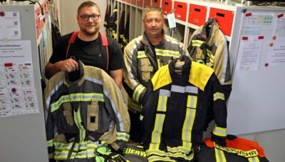 Feuerwehr erhält moderne Schutzkleidung - Gemeindewehrleiter Rico Leuschner (links) zeigt eine der alten Jacken, Ortswehrleiter Sven Weinhold die neue Ausrüstung.