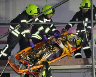 Feuerwehr rettet Verletzte von Gerüst - Harte Arbeit für die Feuerwehrleute: Die mit Seilen gesicherte Trage mit der verletzten Person muss auf die Leiter gezogen werden. 