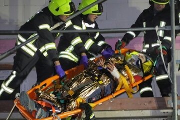 Feuerwehr rettet Verletzte von Gerüst - Harte Arbeit für die Feuerwehrleute: Die mit Seilen gesicherte Trage mit der verletzten Person muss auf die Leiter gezogen werden. 