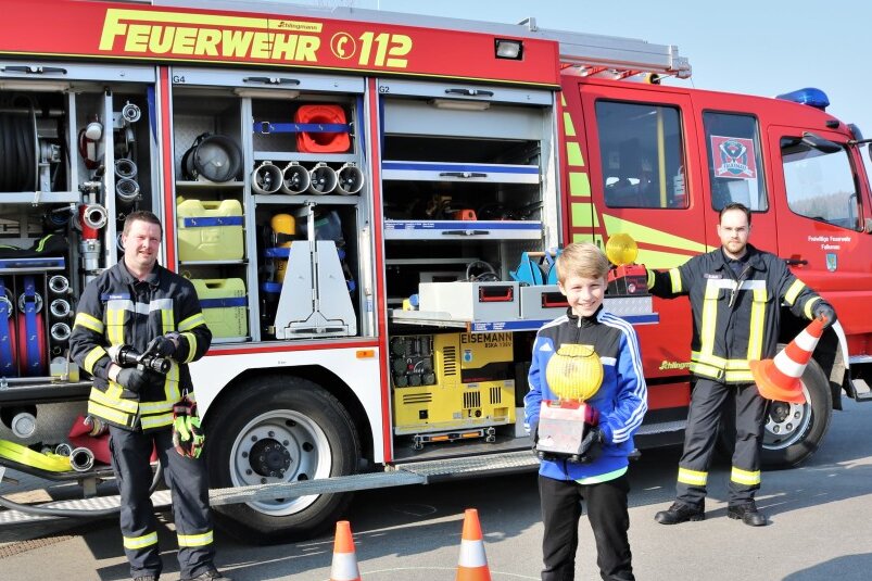 Feuerwehr  revanchiert sich bei  jungem  Falkenauer - Kamerad Sven Stenker (l.) und der stellvertretende  Wehrleiter Bjön Bork (r.) von der Freiwilligen Feuerwehr Falkenau  zeigten dem elfjährigen Tyler Tanneberger (M.) das Feuerwehrdepot und  die Fahrzeuge.